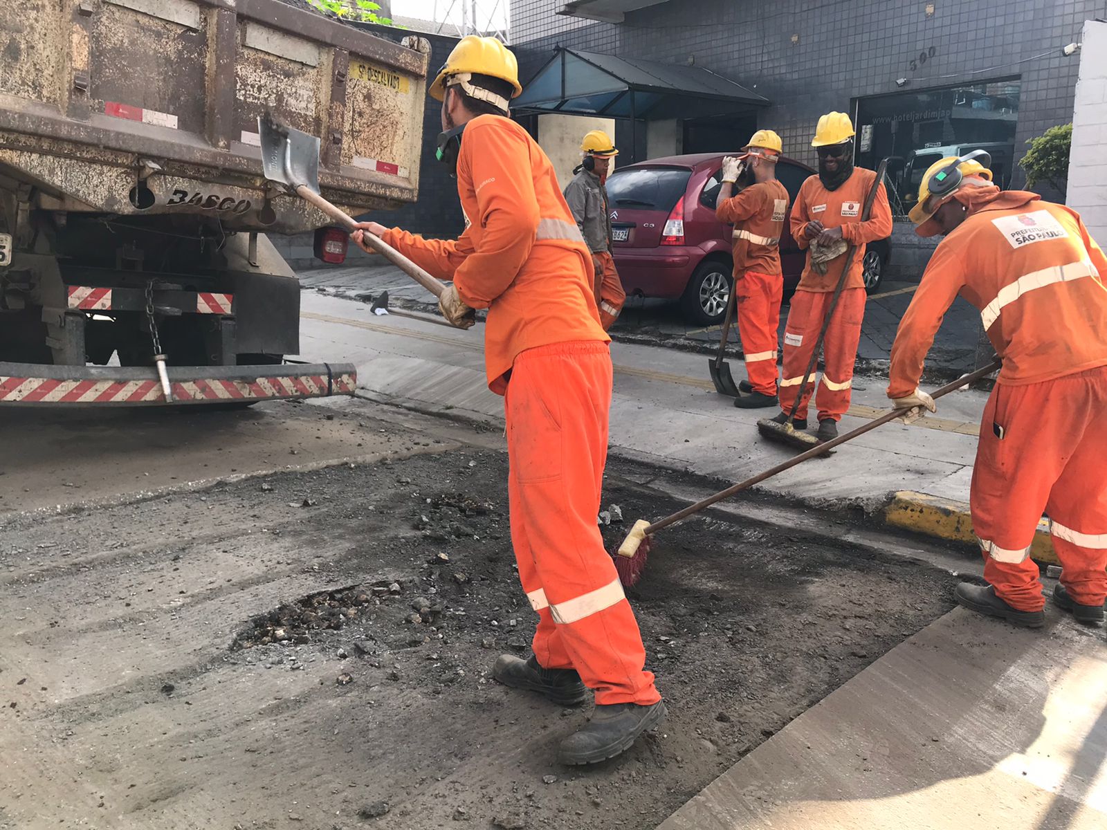 Imagem de trabalhadores em execução do serviço de tapa buracos na Avenida Jardim Japão